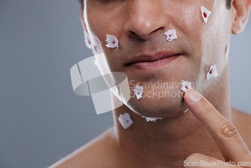 Image of Man, cuts and skincare with close shave, grooming and morning routine on grey studio background. Person, face and model with paper and bleeding with hair removal and irritation with hygiene or facial