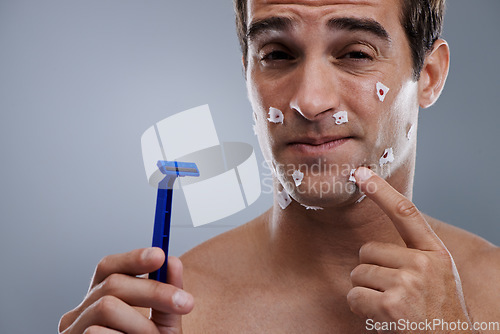 Image of Man, face and shave cuts or pain for hair removal or hygiene injury with blood, tissue or maintenance. Male person, grey background and dermatology with beard or clean health, studio or mockup space