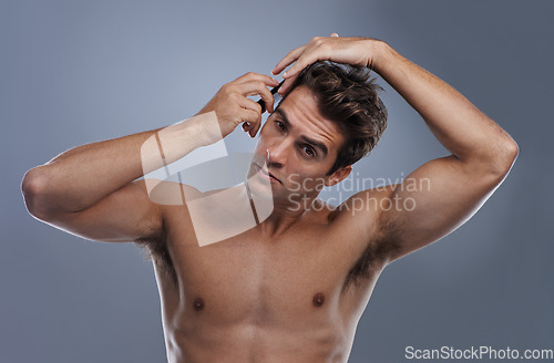 Image of Man, portrait and comb hair in studio for grooming style on grey background for hygiene, self care and shirtless. Male person, model and face with brush for routine in morning, health or mockup space