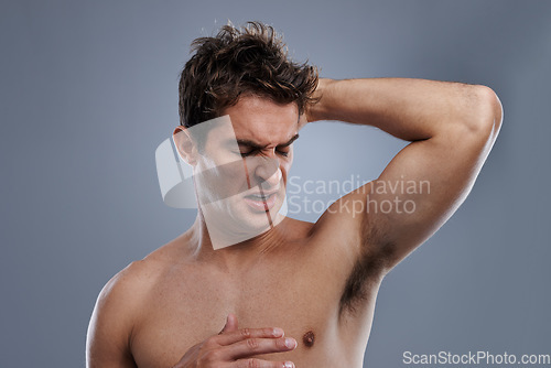 Image of Armpit, stink and man with body odor, poor hygiene and routine on grey studio background for deodorant, cleaning and skincare. Underarm, bad smell and model with hyperhidrosis, sweating or cosmetics