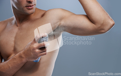 Image of Smell, wellness and man spray deodorant for hygiene, fragrance or fresh scent after shower on studio background. Perfume, product or model spraying armpit to prevent odor and mockup space with person