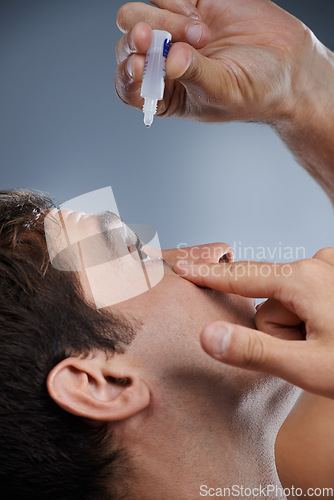 Image of Man, eye drops and vision for allergies or dropper in studio or healthcare wellness, liquid or grey background. Male person, solution and conjunctivitis for clean pupil or dry, irritation or mockup
