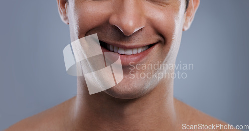 Image of Man, face and smile with skincare and lips with hygiene, jawline and satisfaction with treatment closeup. Grooming, confidence and mouth with young male model in studio background for cosmetic