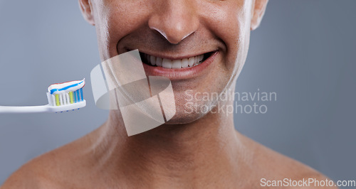 Image of Studio, portrait and person with toothpaste for teeth, oral hygiene and toothbrush for dental cleaning. Model, healthy smile or orthodontics healthcare of whitening or fresh breath by gray background