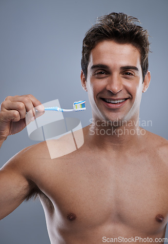 Image of Portrait, man and smile with toothbrush, oral health and body care on grey studio background. Face, person or model with fresh breath or healthy with toothpaste or morning routine with dental hygiene