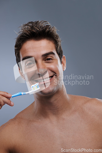 Image of Portrait, toothbrush and man with a smile, clean and morning routine on grey studio background. Happy, person or model with dental hygiene or oral health with fresh breath or toothpaste with wellness