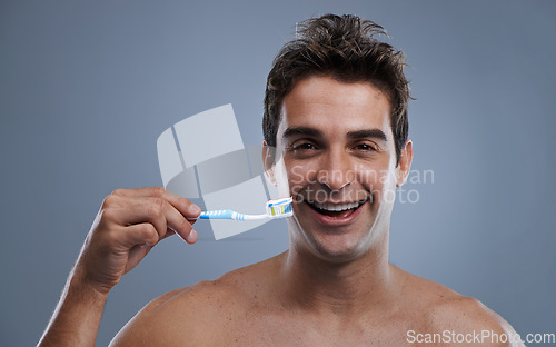Image of Portrait, man or wellness with toothbrush, oral hygiene or body care on grey studio background. Face, person or model with fresh breath or health with toothpaste or morning routine with dental smile