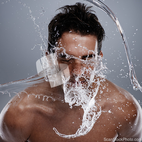 Image of Water drops, splash and man wash face for bathroom routine, self care or beauty treatment. Studio, bathing and male model with facial cleanse for hygiene, grooming and clear skin on grey background