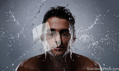 Image of Water splash, liquid and man wash face for bathroom routine, self care or beauty treatment. Eye closed, bathing and model headshot with hygiene, grooming and facial cleanse on dark grey background