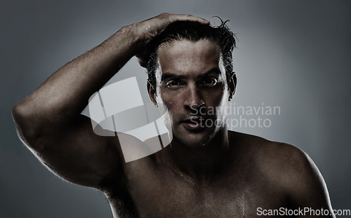 Image of Portrait, man and water with dermatology, sweating and morning routine on a grey studio background. Face, person and grooming with hydration and beauty with model, wet and cosmetics with skincare