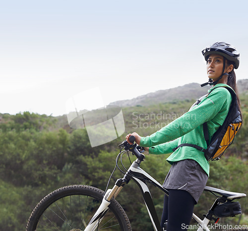 Image of Woman, mountain bike and thinking in nature, fitness and helmet for safety, adventure and mock up space. Girl, bicycle and happy for training, race and outdoor challenge in countryside in Cape Town