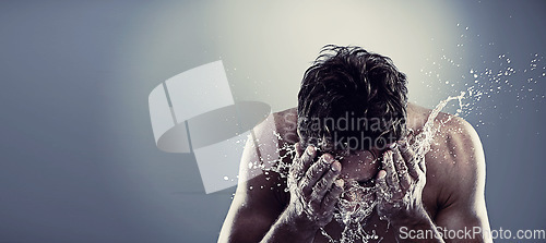 Image of Man, water and splash face in studio for healthy cleaning or skincare hygiene, treatment or grey background. Male person, hands and washing routine for bathroom self care, wellness or mockup space