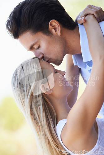 Image of Happy couple, kiss and hug in nature for romance, support or affection in outdoor bonding. Young man and woman forehead with smile for embrace, comfort or love in forest or woods together on date