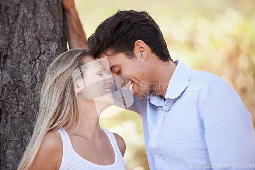 Image of Happy couple, nature and affection for love, support or embrace in outdoor comfort or bonding. Young woman and man relaxing on tree with smile for intimacy or romance in forest or woods together