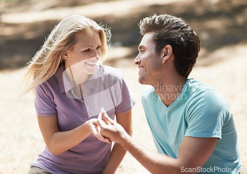 Image of Happy couple, engagement and ring in nature for love, support or commitment in forest or outdoor romance. Young man and woman or lovers smile in embrace or affection for marriage or wedding proposal