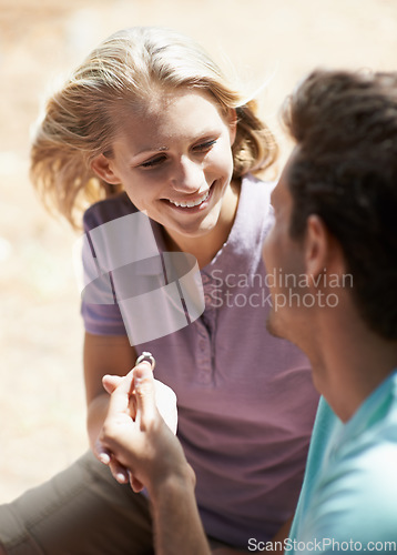 Image of Happy couple, engagement and ring in nature for marriage, love or commitment in forest or outdoor romance. Young man proposing to woman or lovers smile in embrace or affection for wedding proposal