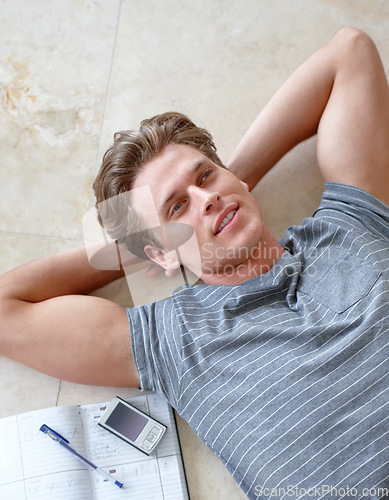 Image of Phone, floor and above of man with notebook and hands on head for resting, learning and writing in home. Studying, education and face of person on ground with book, cellphone and notes on weekend