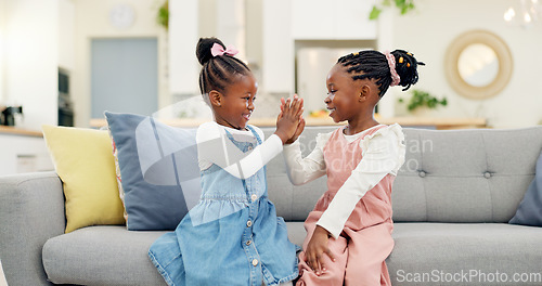 Image of Kids, high five and couch in a home with young, smile and happy from sibling bonding together. House, lounge sofa and daughter friends with talk and girl friendship with fun and youth in living room