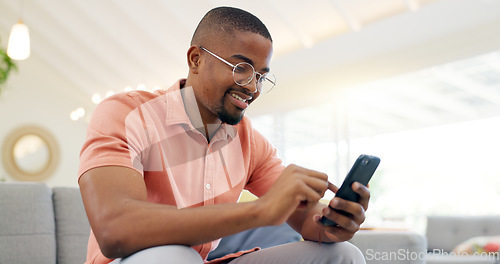 Image of Happy, typing and a black man with a phone on the sofa for social media, connection or communication. Smile, relax and an African person with a mobile for an app, email or notification in a house