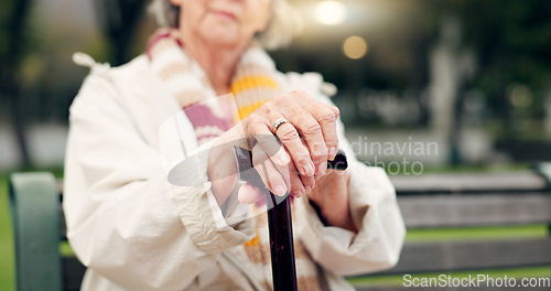 Image of Walking stick, hands and senior woman closeup on a park bench with person with disability. Mobility support, wellness and balance with cane and elderly female person outdoor in a public garden