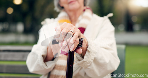 Image of Walking stick, hands and senior woman closeup on a park bench with person with disability. Mobility support, wellness and balance with cane and elderly female person outdoor in a public garden