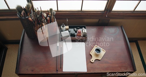 Image of Art, paint brush and painting tool for painter, calligraphy and drawing at a desk for creative work. Sketch paper, Japanese sumi and home studio with ink pot and document for creativity above