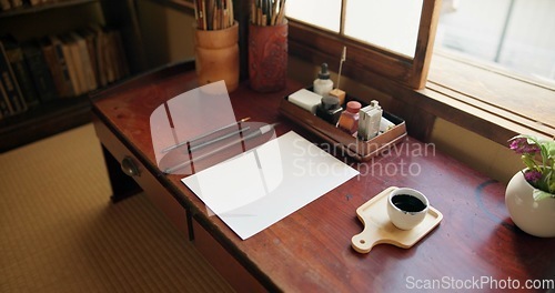 Image of Ink, paint brush and Japanese art with paper on a desk in a home studio with creativity tools. Creative, painter paperwork and artist with sketch document and calligraphy with pencil and drawing
