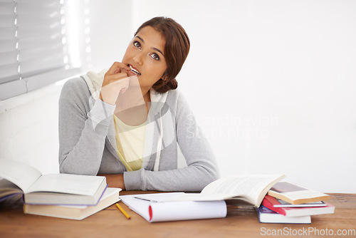 Image of Student, woman and thinking with books for learning, knowledge or education with idea for study in bedroom..Young person, girl and thoughtful at desk with novel for scholarship, project or assessment