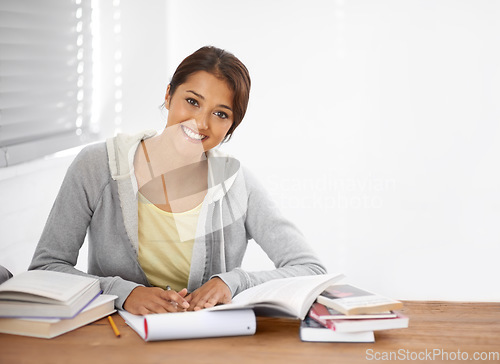 Image of Student, woman and portrait with books for study, knowledge or education with notes for project in college..Young person, face and learning at desk with novel for scholarship, happy and assessment