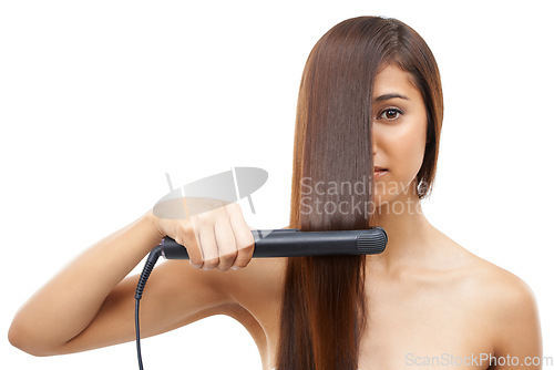 Image of Hair care, straightener and young woman in studio for cosmetic, salon and beauty treatment. Flat iron tool, confident and portrait of female person with healthy hairstyle routine by white background.