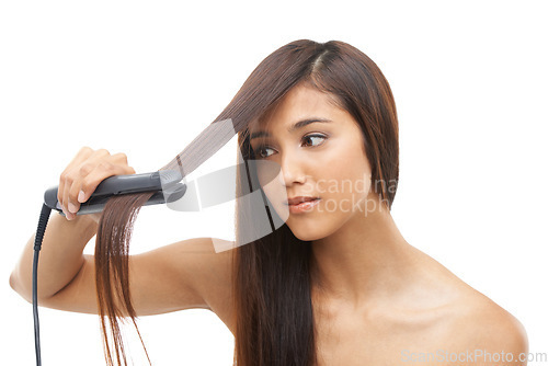 Image of Hair care, straightener and young female model in studio for cosmetic, salon and beauty treatment. Flat iron tool, confident and woman with healthy and shiny hairstyle routine by white background.