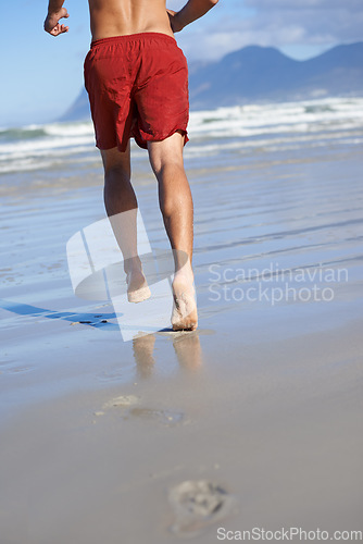 Image of Man, lifeguard and legs running on beach for security, safety and outdoor swimming emergency. Rear view or back of male person or professional swimmer ready on patrol or rescue at sea or ocean coast