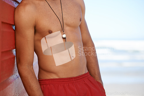 Image of Muscular man, lifeguard and whistle at beach for security, emergency or help in surveillance, alert or safety at bay. Person, athlete or professional swimmer ready to assist on mockup space at ocean