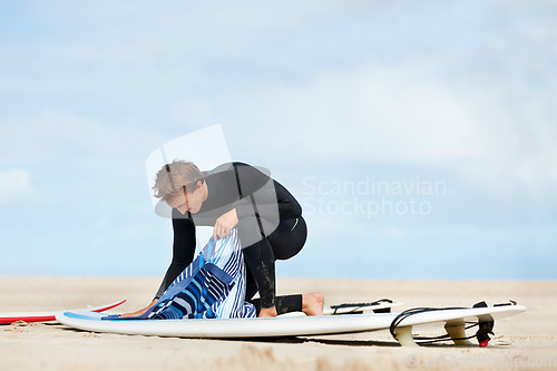 Image of Surfer, man and getting ready with surfboard in nature with wetsuit, blue sky or preparing with mock up space. Extreme sports, athlete and person outdoor for training, surfing workout or watersports