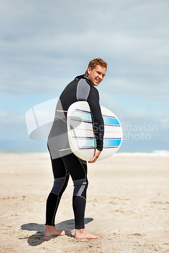 Image of Surfer, man with surfboard and beach for fitness and extreme sports, wet suit and happy in the sun. Summer vacation with adventure and surfing in nature, ocean and exercise with hobby in Australia