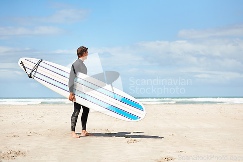 Image of Surfing, thinking and man with surfboard on beach for water sports training, wellness and fitness by ocean. Nature, sky and person with mockup space for adventure on holiday, vacation or hobby by sea