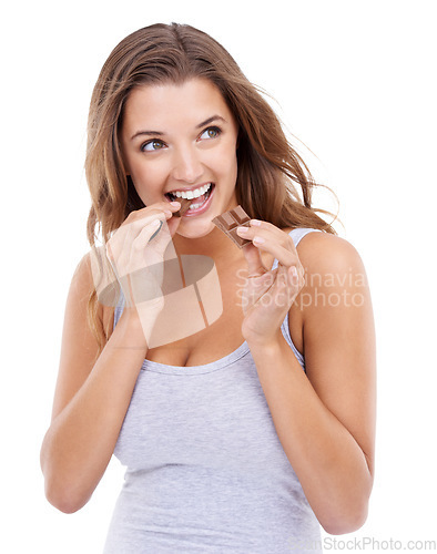 Image of Happy woman, eating chocolate and enjoy candy with sweet tooth, pleasure and craving sugar in studio background. Hungry, snack and meal for comfort, dessert and sweets for calories, diet and bite