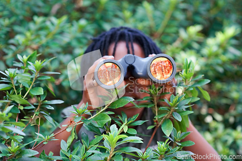 Image of Boy, kid and binoculars for search in nature while learning and fun in forest or adventure at summer camp. Young African child, green leaves and explore environment outdoor with youth and discovery