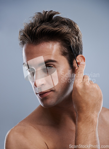 Image of Hair, studio and portrait of man with comb for wellness routine, grooming treatment or haircut styling. Self care tools, spa salon and face of aesthetic model with hairstyle brush on grey background