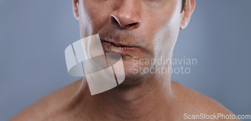 Image of Man, mouth and angry with shave, face and hygiene with skincare, upset, and frustrated with treatment closeup. Grooming, mockup space and moody with male model in studio background with cosmetics