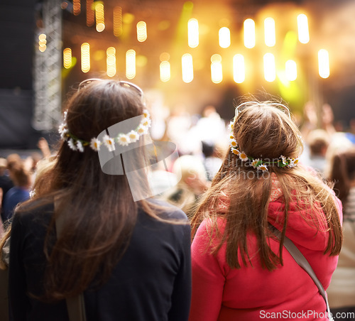 Image of Women, friends and music festival in audience at outdoor concert, listening to live band. Female people, stage and watching entertainment in park for fun holiday weekend rave, vacation at party event