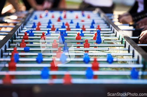 Image of Foosball table, competitive and leisure with people playing a game outdoor at a music festival together. Party, event or social gathering with friends at a carnival for tabletop soccer or football