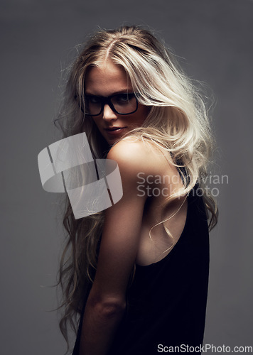 Image of Portrait, woman and glasses in studio with fashion, style and trendy aesthetic with positive by gray background. Model, pride and eyecare on face with attitude, blonde and cool in sunglasses