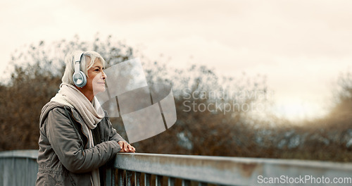 Image of Bridge, senior woman and headphones with music and thinking outdoor with view. Elderly female person, web radio and mockup space feeling relax in retirement with audio and freedom on calm holiday