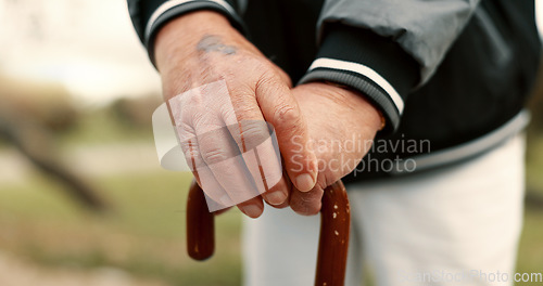 Image of Hands, cane and elderly man in nature for walking for fresh air, exercise or peace in a park. Environment, closeup and senior male person in retirement with a stick for support in outdoor garden.