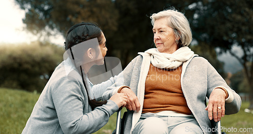 Image of Caregiver helping woman with disability in park for support, trust and care in retirement. Nurse talking to happy senior patient in wheelchair for rehabilitation, therapy and conversation in garden