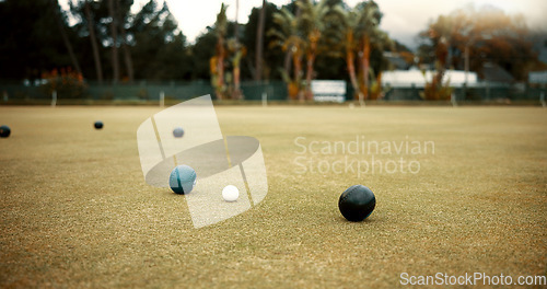 Image of Green, lawn bowling and balls on grass, field or pitch in a match, game or competition of outdoor bowls. Ball, sport and tournament at a bowlers club, league or championship games on the ground