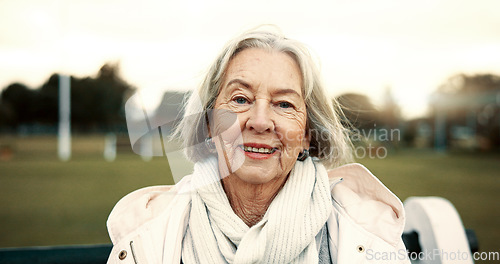 Image of Face, senior woman and smile on park bench on vacation, holiday or travel in winter. Portrait, happy and elderly person in nature, garden or outdoor for wellness, freedom and relax in retirement