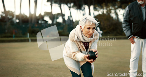Image of Senior woman, bowling and park on grass for sport, fitness and games for competition, health or fun. Elderly people, metal ball and lawn for contest, funny laugh or workout with blowing for good luck