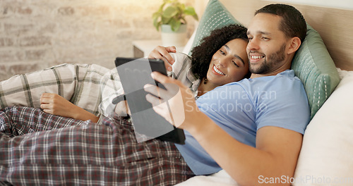 Image of Couple, tablet and scroll in bed, morning and bond with internet video, movie and meme for love, care and hug. Man, woman and digital touchscreen for typing, social network app or web blog in house